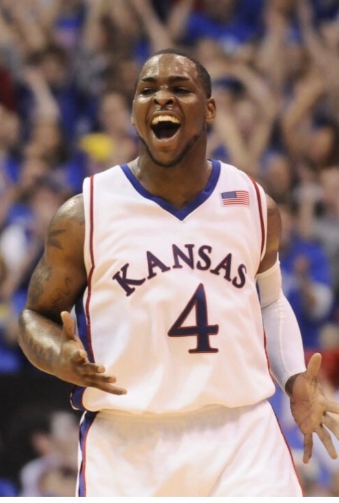 A Kansas Jayhawks player in a number 4 jersey celebrating at Allen Fieldhouse